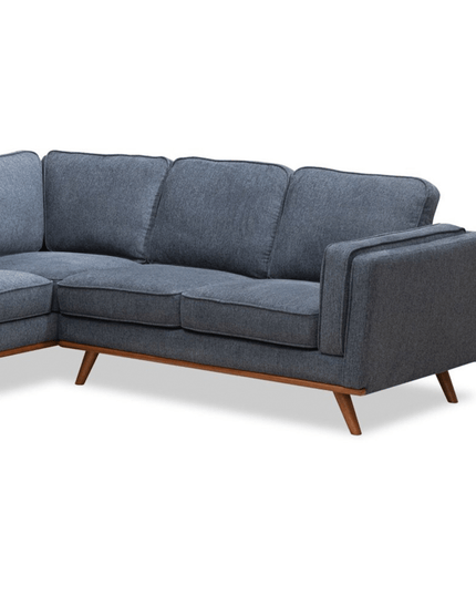 Introducing the Maddox RSF: a modern gray L-shaped sofa with wooden legs and plush cushions. This minimalist piece features a sturdy frame and clean lines, ideal for a mid-century modern living room setting.