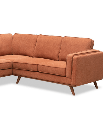 The Maddox RSF is an orange mid-century modern L-shaped sofa with wooden legs, clean lines, and tufted back cushions, adding a retro feel to your decor while providing plush cushions for ultimate comfort.