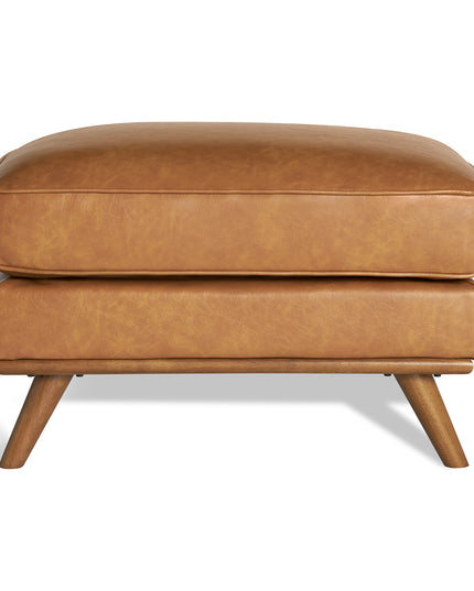 Meet the Maddox Ottoman: a rectangular brown leather piece with four angled wooden legs, complemented by a plush cushion. This cozy yet stylish ottoman adds mid-century modern charm to any living area against a simple white background.