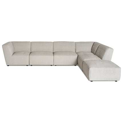 The Millenium 5 Piece + Ottoman is a large, modern luxury L-shaped sectional sofa with beige upholstery. Featuring cushioned seats, a low backrest, and small dark feet, its ideal for spacious living areas and provides a minimalist, contemporary look.