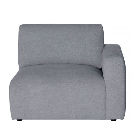 The Lugano Right Arm is a modern, minimalist gray armchair with a square design. It features a thick cushioned seat and right-side armrest, crafted from premium materials. Its subtly textured fabric adds elegance, all set against a plain white background.