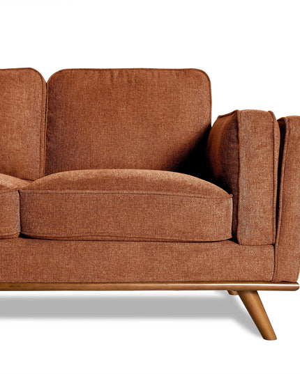 A close-up of the Maddox sectional with a wooden base in brown fabric highlights its angled legs and plush cushions, offering a cozy mid-century modern style perfect for any living room.