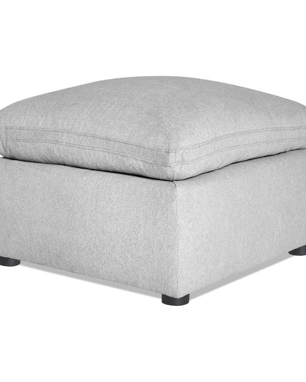 The My Cloud 30 Ottoman showcases a gray, plush cushion on a sturdy base with four black legs. This customizable piece combines minimalist design with comfort and style, perfect for any living space.