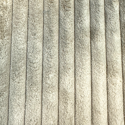 Close-up of beige, ribbed, corduroy fabric with vertical stripes. The material seems soft and plush, resembling fleece or a cozy part of the Yeti 6 Piece Pit.