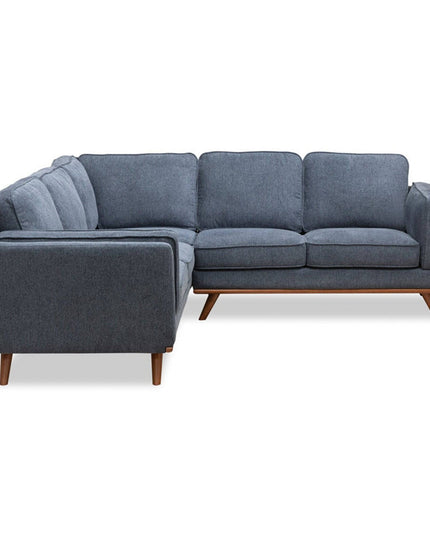 The Free Fabric Swatches offer showcases a modern sectional sofa with an L-shaped design, dark gray fabric, and wooden legs. Cushioned seats and backrests are set against a plain white background.